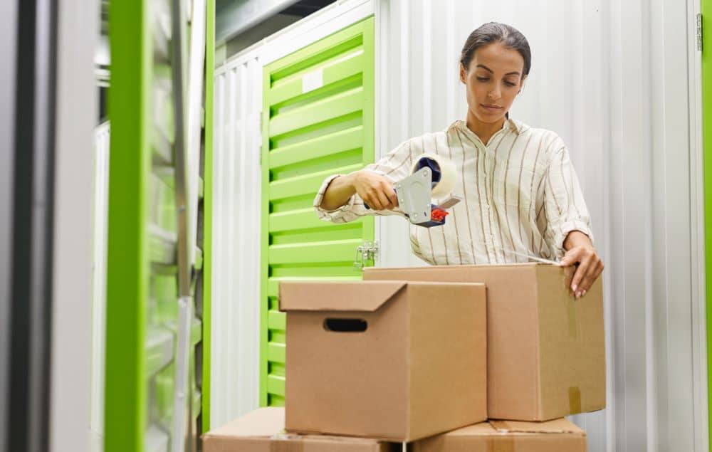 Woman storing boxes in self-storage facility.